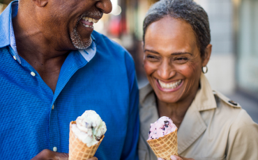 a mature couple smiling while eating ice cream